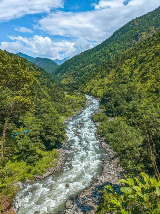 the water is flowing through the green mountains