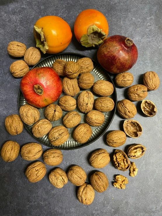 some nuts are arranged next to an apple and orange