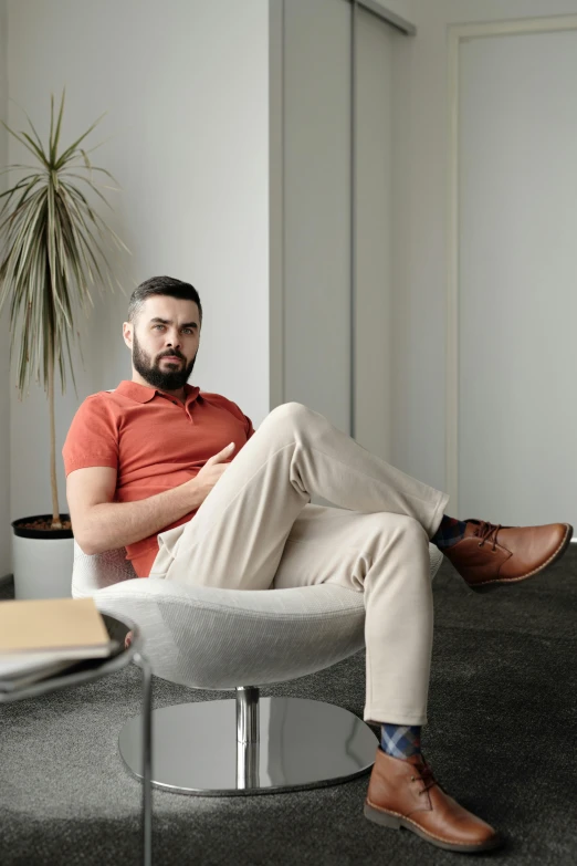 a man sitting on a chair, with one foot on the ground