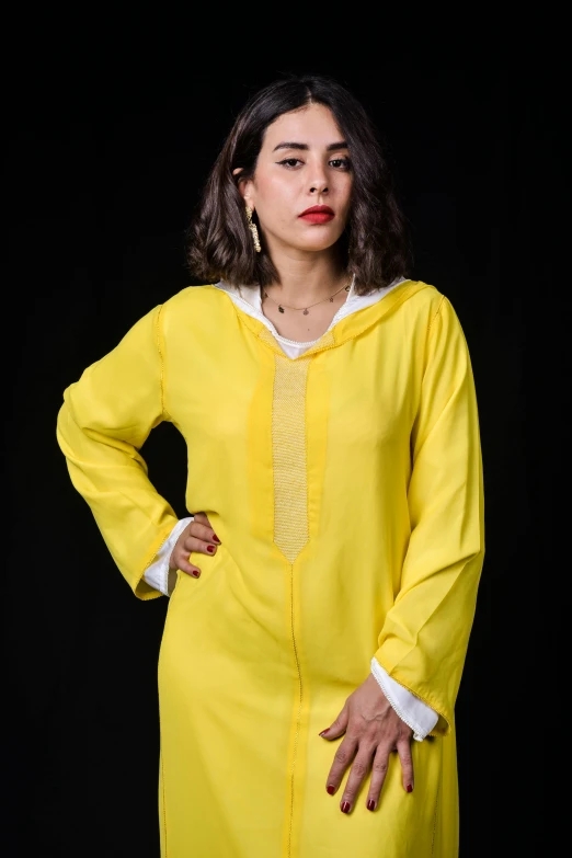 a woman standing with her hands on her hips wearing yellow