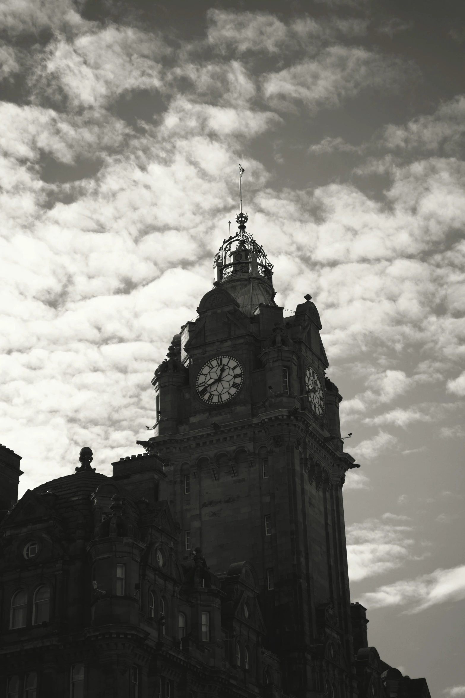 an old clock tower rises into the cloudy sky