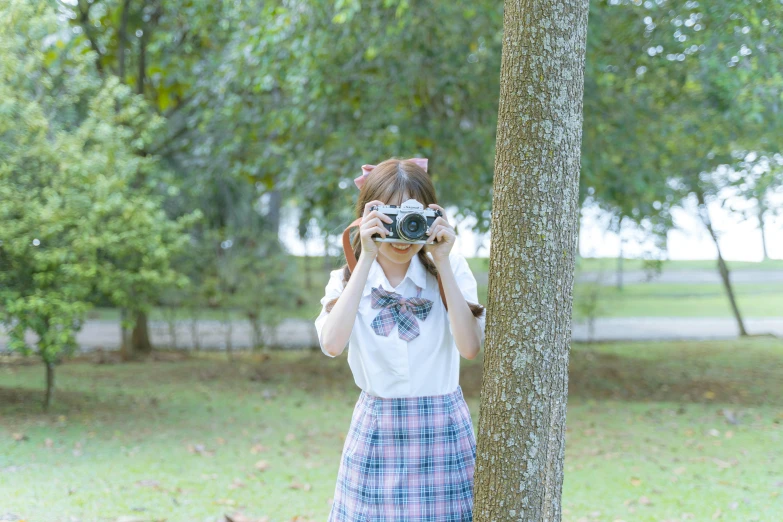 a woman in plaid skirt taking pictures with a camera