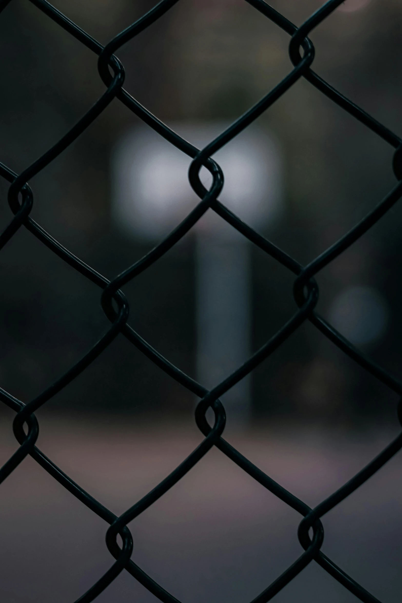 an umbrella hanging from a black chain link fence