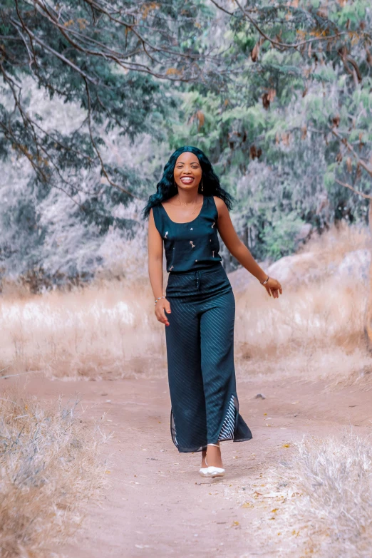 a smiling woman walking down a dirt road