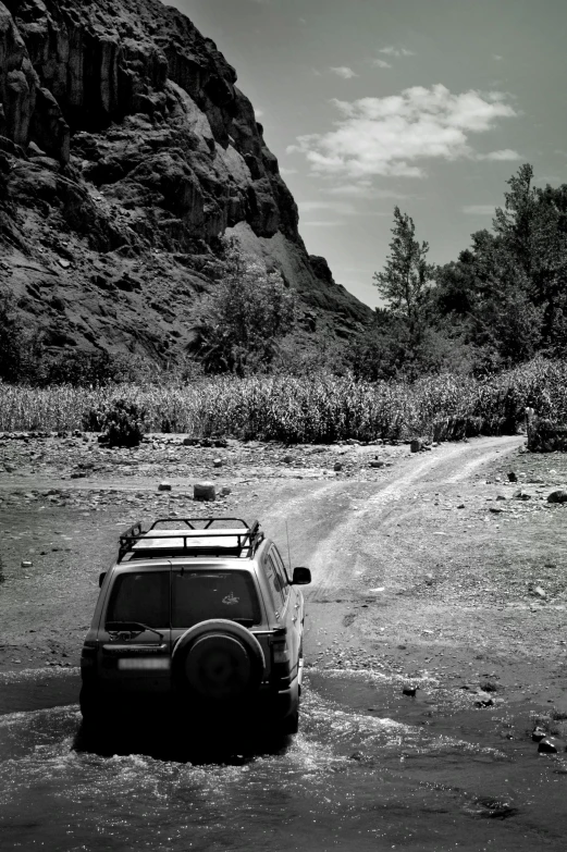 a four wheel drive jeep driving through mud covered ground