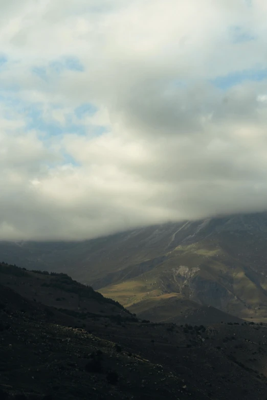 two people flying an umbrella on the top of a mountain