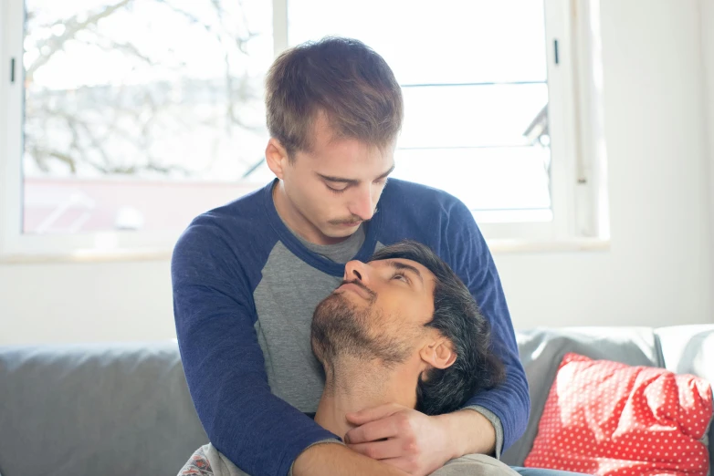 a man has his face pressed against a woman's shoulder