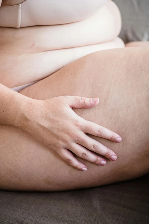 a woman's  is partially open and her left hand rests on the belly