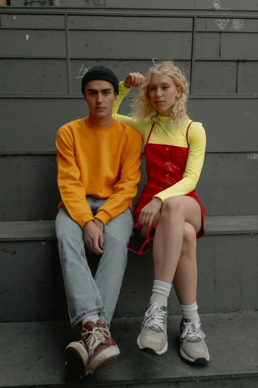 a young man and woman sit on steps together