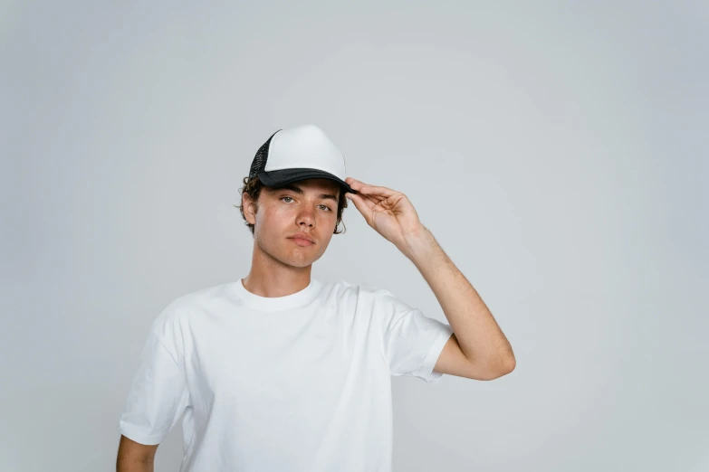 a man wearing a white t - shirt and black hat