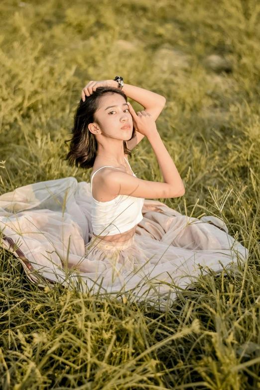  in dress sitting in grass on grassy hill