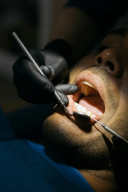 a man in a dental emergency using a dental tools