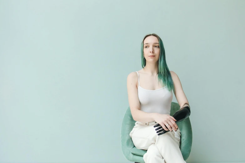 a girl with green hair is sitting on a bean chair