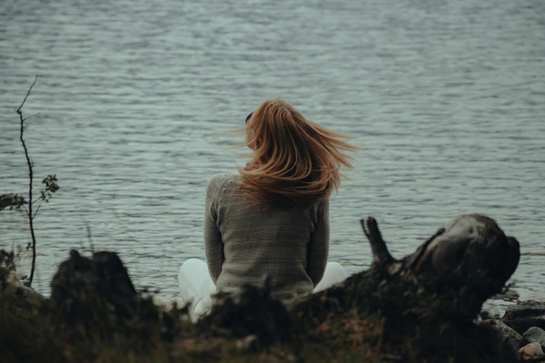 a person sitting by a body of water