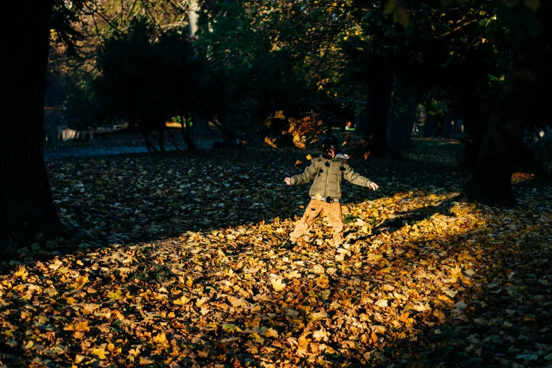 a  throws leaves at her back as she walks in the park