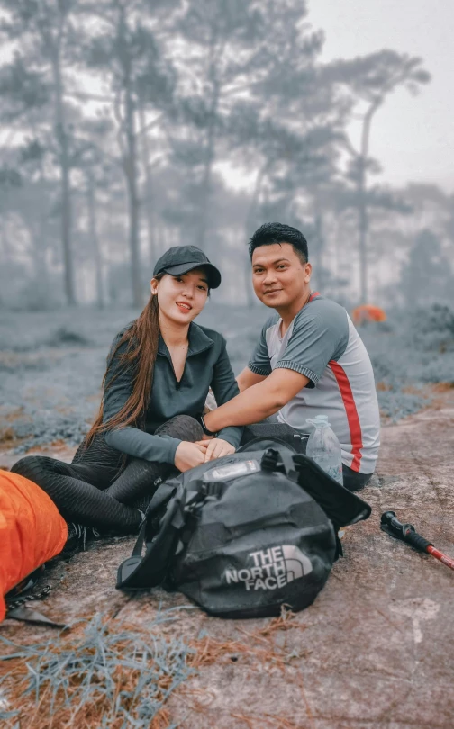 a man and a woman smile while sitting next to each other on the ground