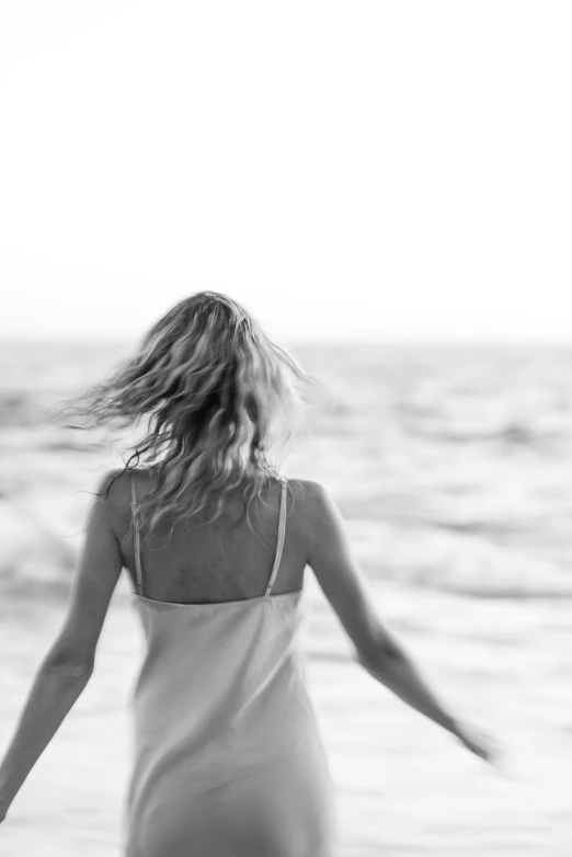 black and white po of woman in back dress by water