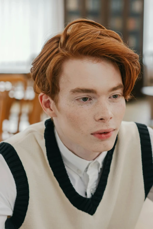 a young man with red hair wearing a vest and tie