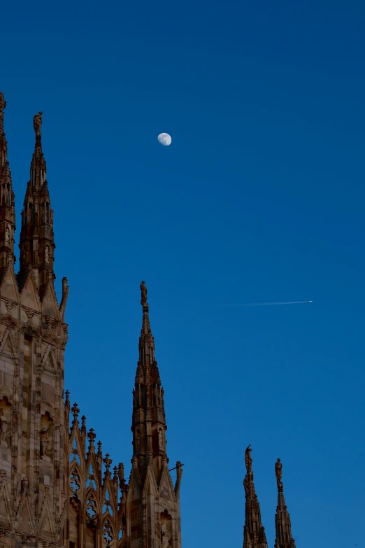 a full moon in the sky over many tall buildings