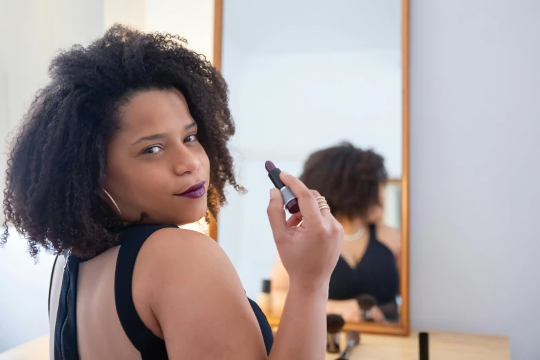 a woman with a concerned look stares ahead while holding her brush