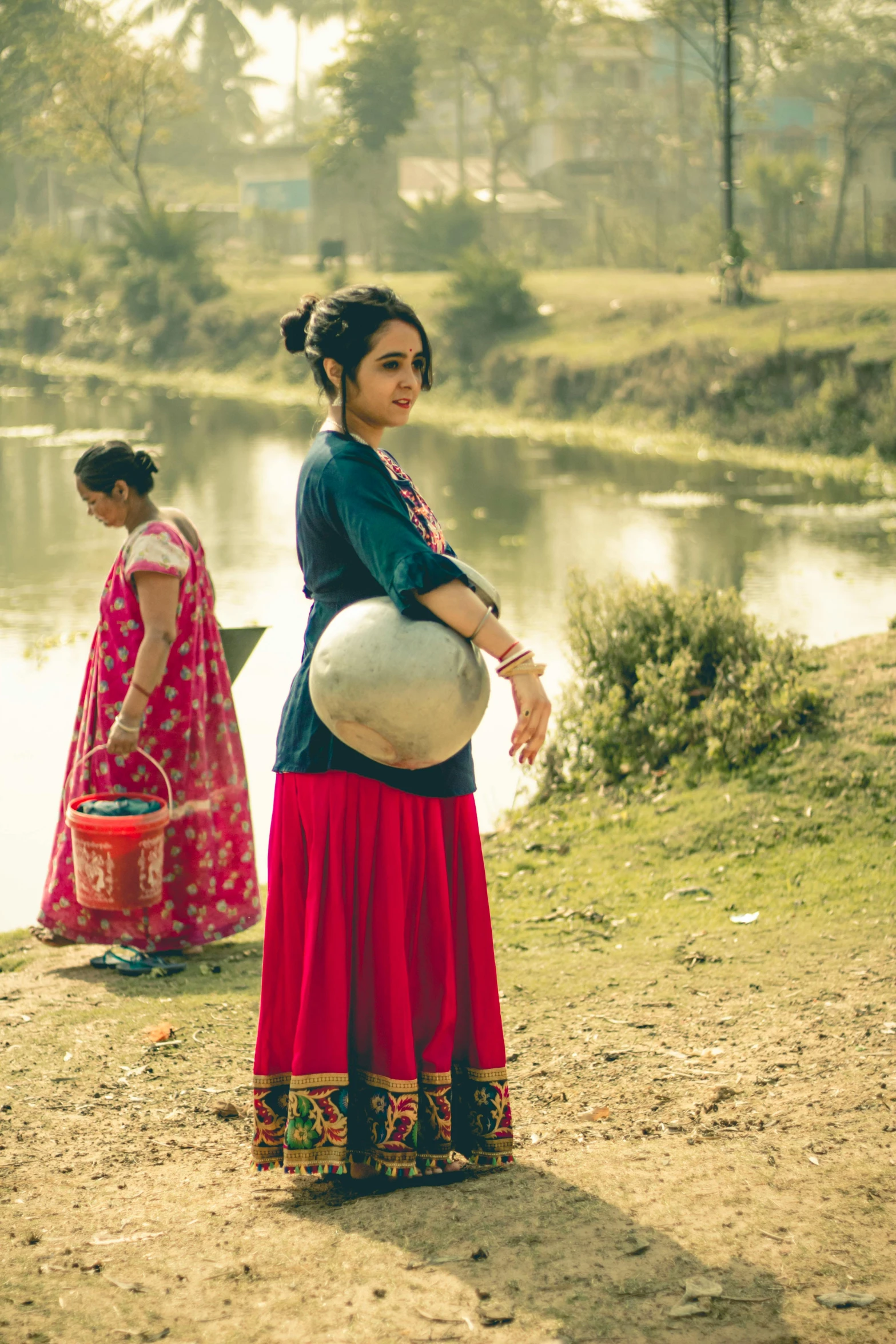 the woman in the long skirt is carrying a large ball