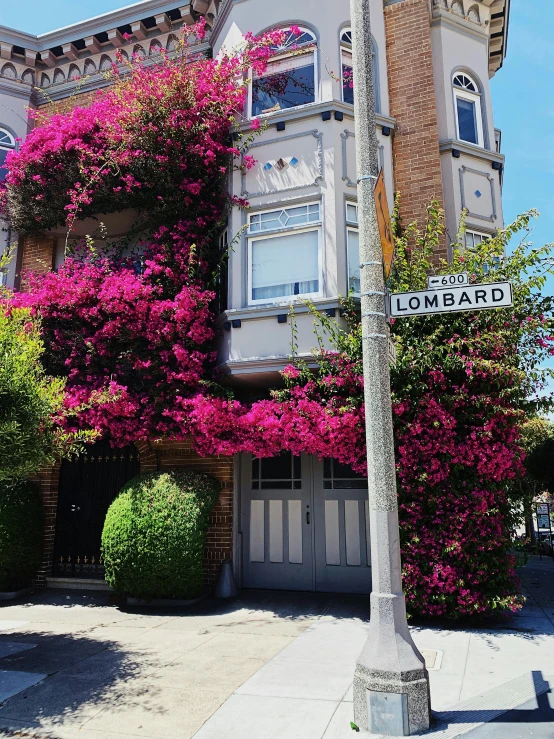 an old victorian house with beautiful flowers around it