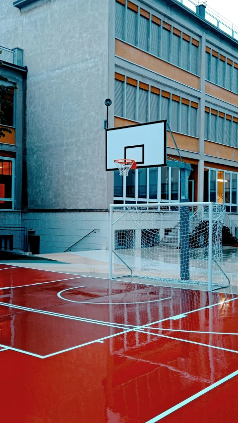 a basketball court outside an office building that has a basketball hoop in it