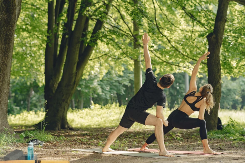 the man and woman is engaged in yoga outside