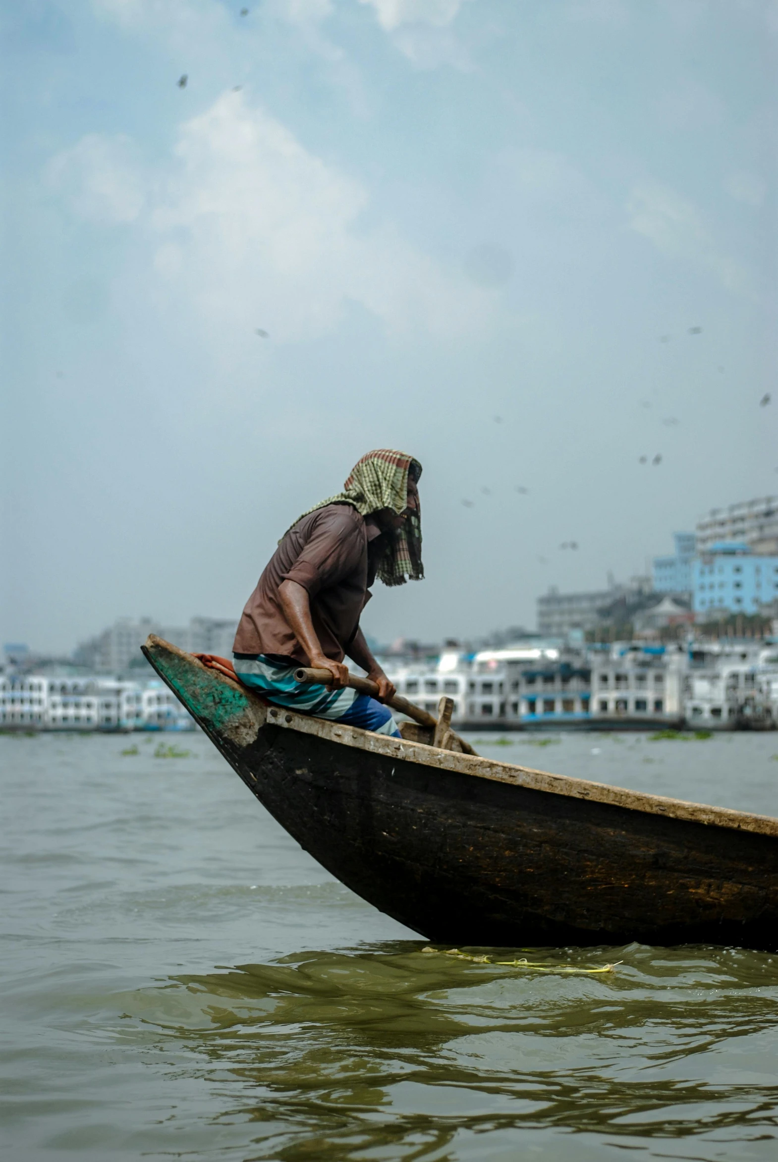 a man sitting in a canoe in the middle of the water