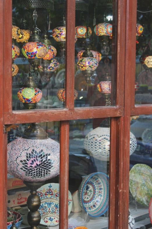 various vases sit behind a glass window