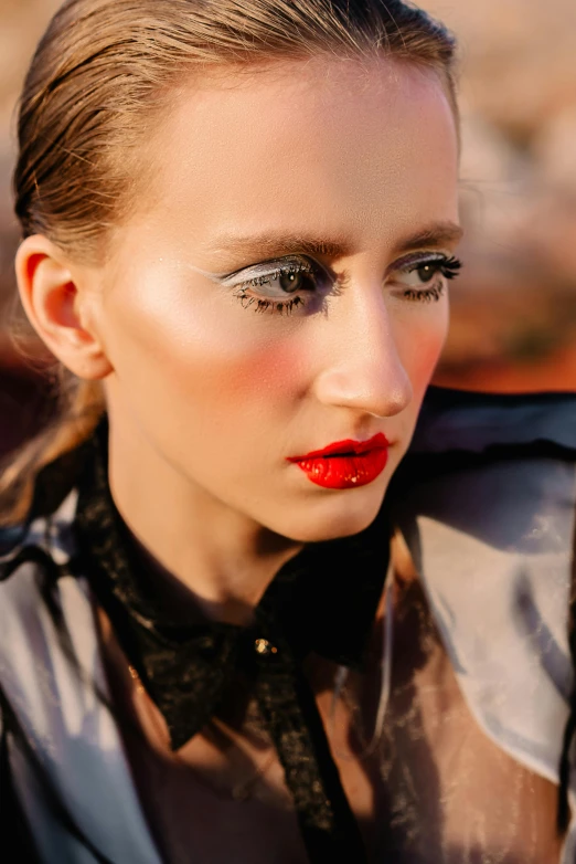 a woman with red lipstick and eyeliners has her face close to the camera