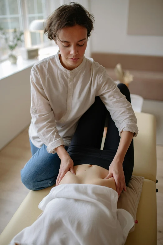 a woman is sitting down getting her massage
