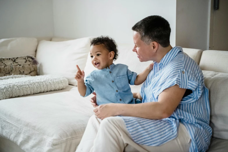 a man sits on a couch holding a toddler