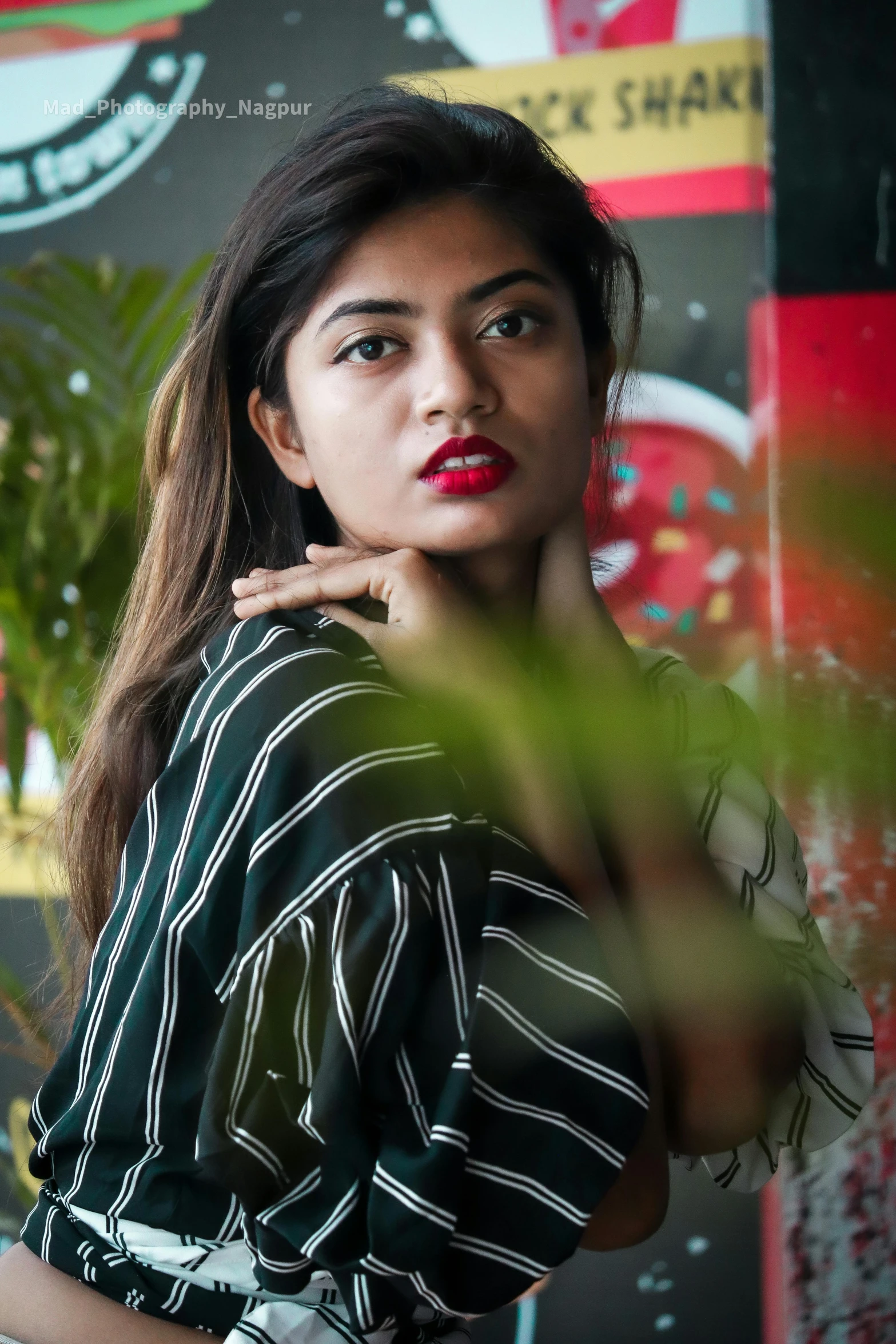 the woman stands near a wall wearing a green top