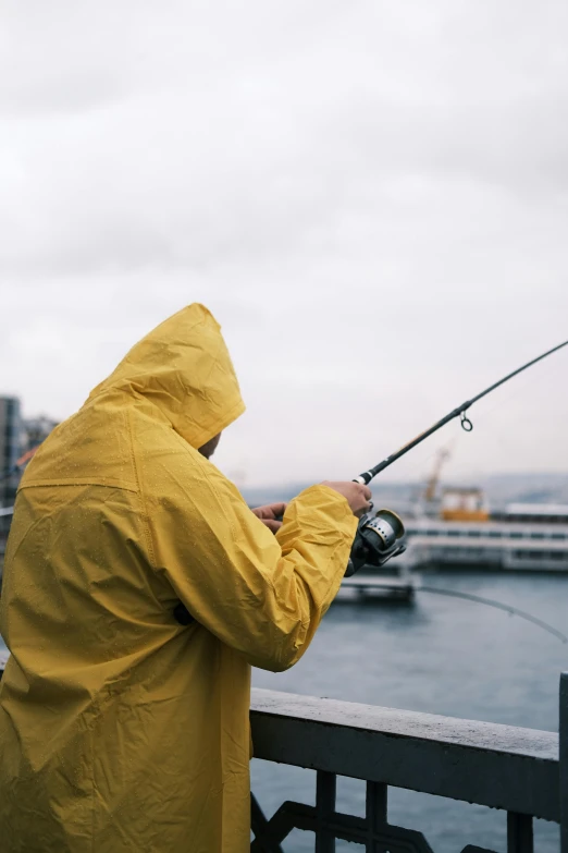 a man fishing with his cell phone and a fishing pole