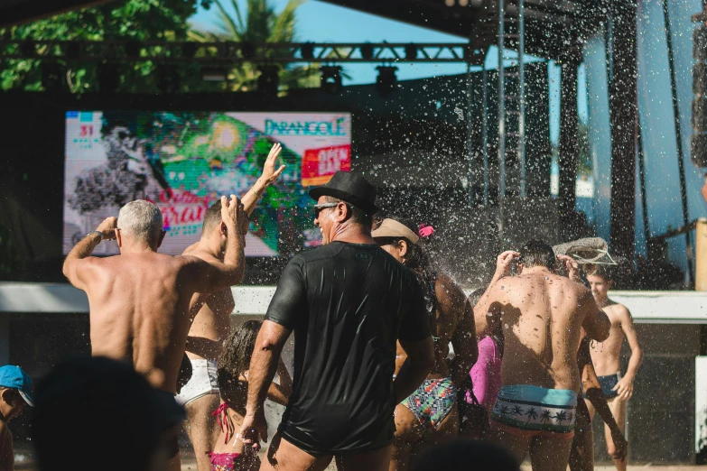 men in bathing trunks and hats enjoying a splash