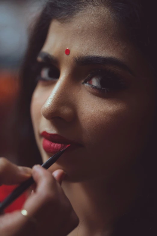 a close up of a person doing makeup