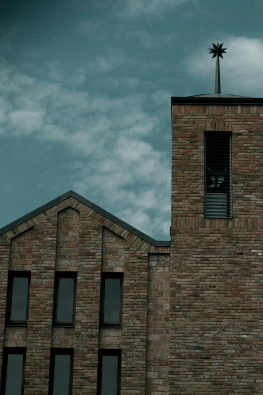 the clock tower of a brick building is lit