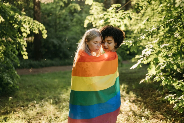 two women are wrapped in a colorful blanket