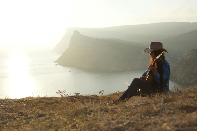 there is a man that is sitting on the hill looking at soing