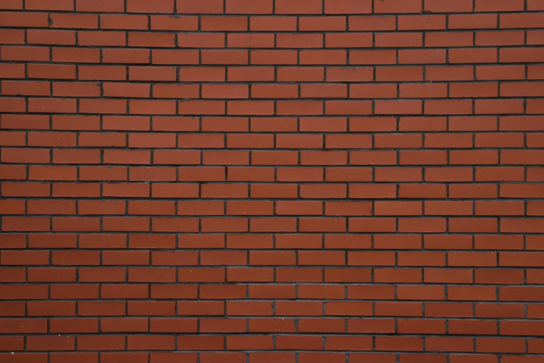 an empty bench sitting against a brick wall