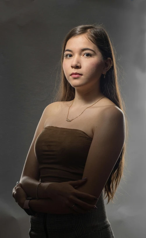 an attractive young woman wearing a tube top posing for a portrait