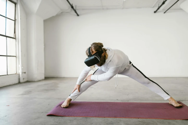 a woman doing yoga in a studio while wearing a mask