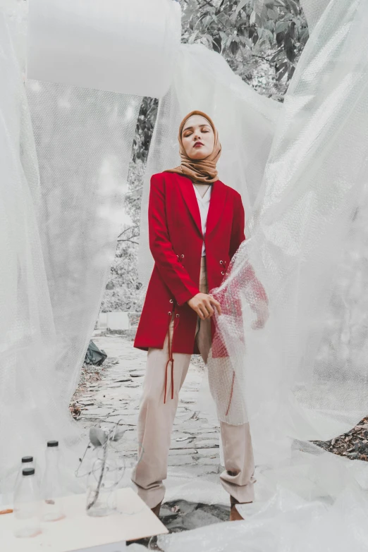 the woman stands in a tent covered in plastic sheets