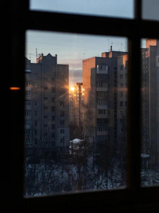 sunsets in the city with large building seen out window