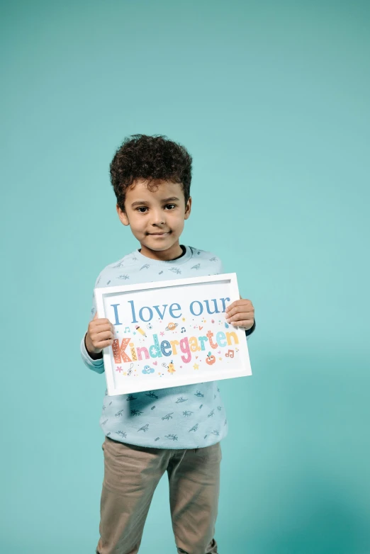 the child is holding up a sign that reads i love our children