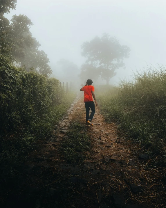 person in red jacket walking down the trail