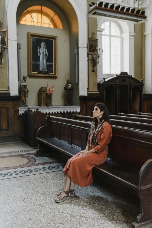 a woman sitting on a bench in a church