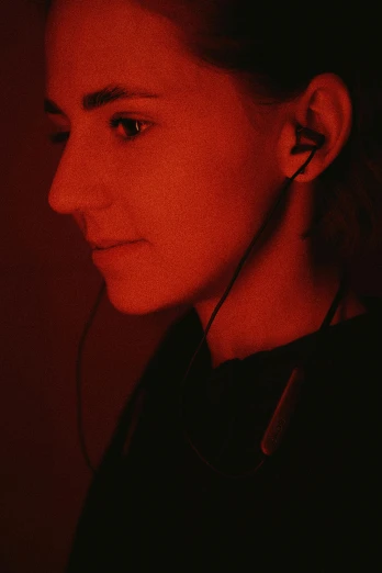 a woman wearing earbuds on a red background