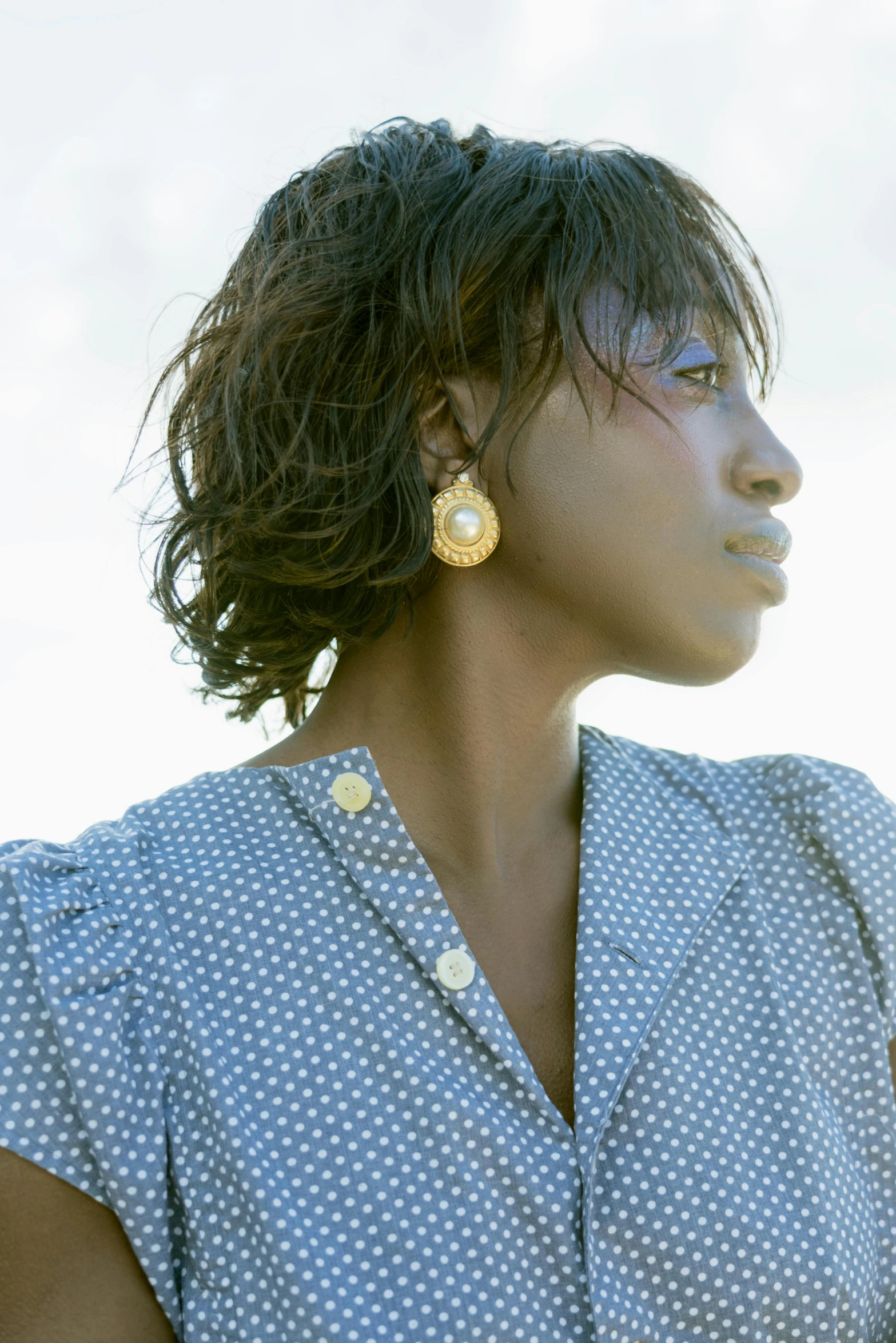 a woman with short hair is wearing an earring